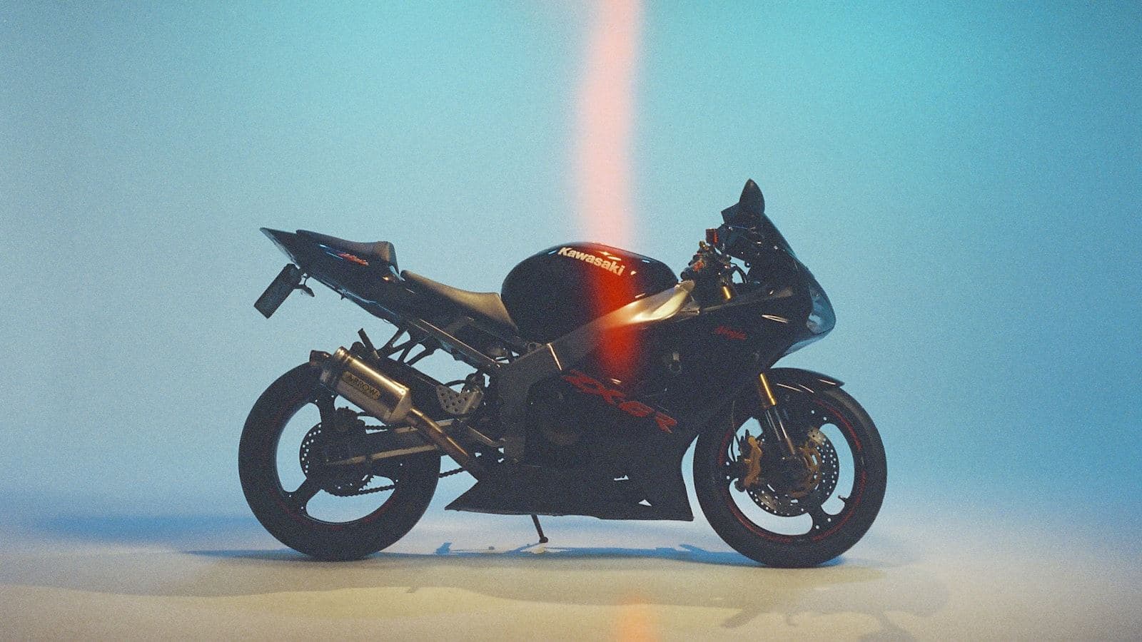 Black sport motorcycle with red accents in a studio setting